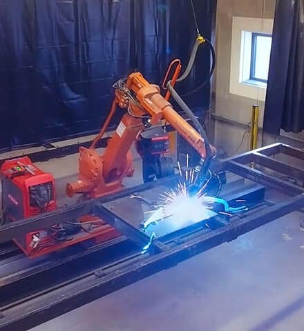 Orange svejserobot fra ABB som svejser hos NMF Industries efter opgradering